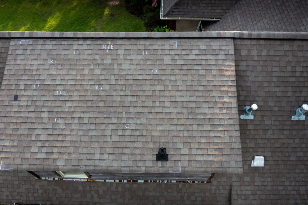 Close-up of a roof with missing shingles showing storm damage.